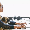 A woman prioritizing the benefits she offers to her employees. A puppy sits in her lap.